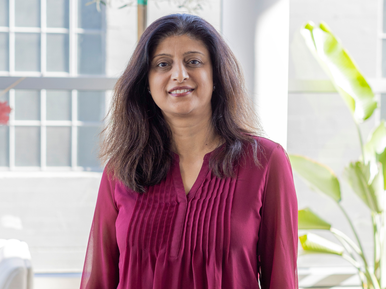 Shibani Sanan the new chief technology officer at Ladder stands in the Ladder office wearing a red shirt